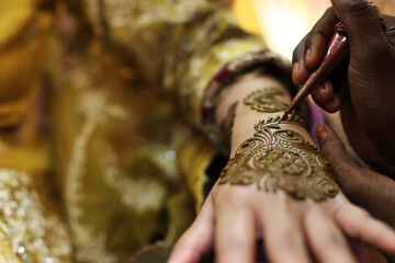 A Bride getting henna applied on her hands. Very beautiful Mehendi design on the hands. Wedding culture in Asia. 