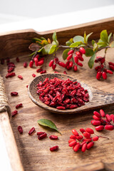 Pile of dried Berberis vulgaris also known as common barberry, European barberry or barberry on plate in home kicthen. Edible herbal medicinal red fruit plant.