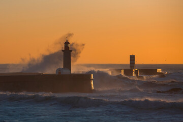 View of a lighthouse, washed in the twilight by a wave. Porto, Portugal.
