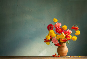 red and yellow flowers on jug in sunlight on background dark wall - Powered by Adobe