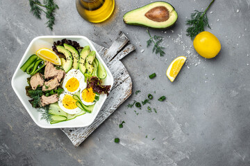 Tuna vegetable vegetarian buddha bowl avocado, egg, cucumber and fresh salad on a light background....