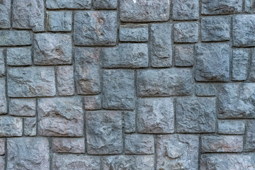 texture of a grey stone wall made of stones with concrete