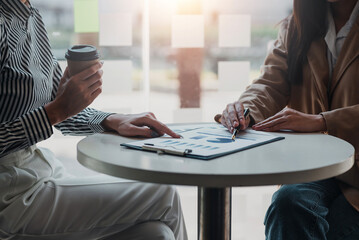 Business people meeting marketing investment analysis concept pointing to graph and chart at office.