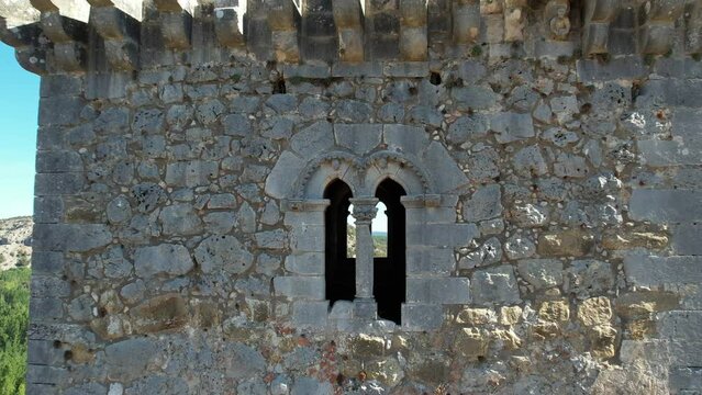 Geminated stony window in a splandid  medieval tower backward view. Ucero, Spain.