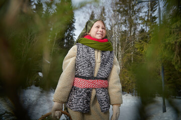Nice cute teenager girl in old peasant clothes with hot fur coat and shawl in cold winter forest...