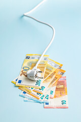 Electric plug and euro money on blue background. Concept of increasing electric prices.