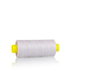 skein of beige color thread macro on a white background