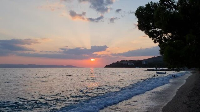 Sunset over the sea. Scenic view of sea and sky. Waves on the beach. Beautiful sunset on the beach.