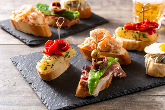 Assortment of Spanish pintxos on wooden table
