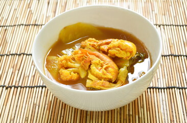 boiled zhrimp and mixed vegetable in spicy and sour prange curry soup on bowl 
