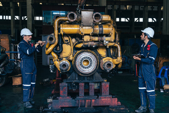 the technician repairing and inspecting the big diesel engine in the train garage 