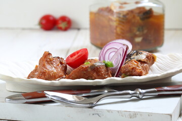 Catfish canned in a tomato in a glass jar on a white background
