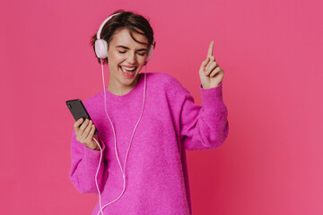 White young woman wearing sweater listening music and singing