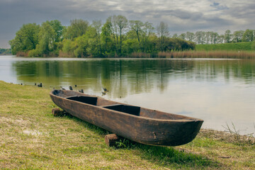 starodawna łódka na brzegu jeziora - obrazy, fototapety, plakaty
