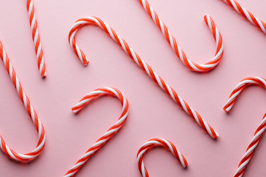 Pattern of hard striped candy cane on pink background. Christmas holidays background
