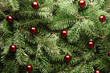 Creative Christmas holidays background with fir twigs and red christmas balls closeup. Flat lay, top view. Merry Christmas