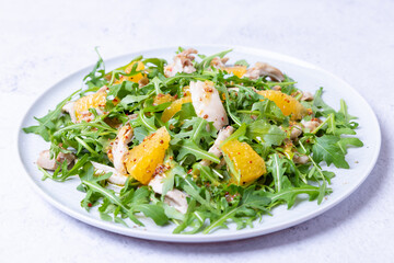 Salad with chicken, oranges and arugula. Dressing with olive oil and grain mustard. Close-up.