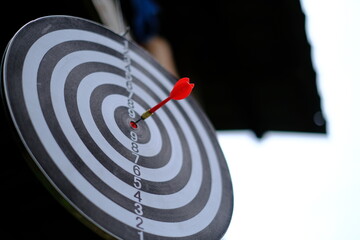 Red dart arrow hitting in the target center of dartboard Target hit in the center.