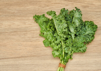 top view fresh green Kale leaves bunch leaf cabbage on wooden table background. green kale or leaf cabbage                                                   