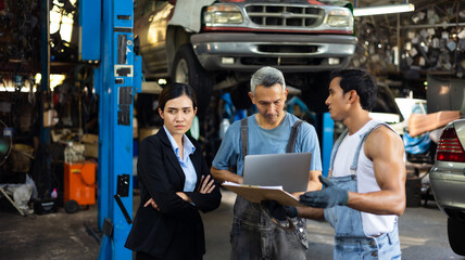 Serious asian young woman customer talking with owner and mechanic worker at car repair service and auto store shop.