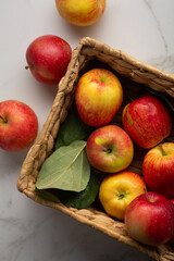 Yellow and red apples in crate on light surface food harvest concept