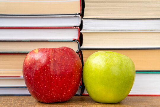 Red And Green Apples With Books Stacked On Background