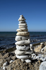 Fototapeta na wymiar Empilement de cailloux en équilibre sur une plage de galets sur l'île d'oléron en France