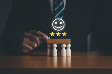 A businessman puts a wooden block on a wooden puppet. Management concept in the organization. Teamwork. Successful work with three-star quality.