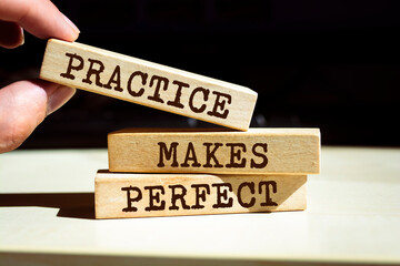 Wooden blocks with words 'Practice Makes Perfect'. Business concept