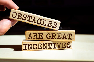 Wooden blocks with words 'Obstacles Are Great Incentives'. Business concept
