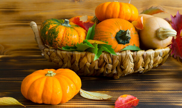 Full basket with pumpkins on wooden background. Image with selective focus