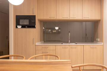 Front view of double modern kitchen in oak and white colors with dining area