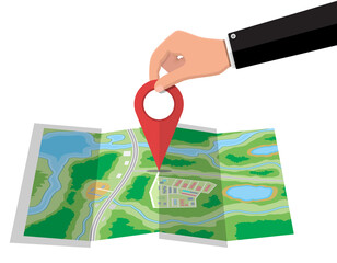 Location pin in hand and paper map.