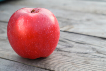 Red ripe apple on a rustic gray wooden boards. Copy space