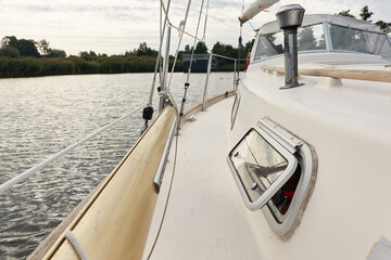 Sloop rigged sailboat (for rent and sale) moored to a pier in a yacht marina. Nautical vessel,...