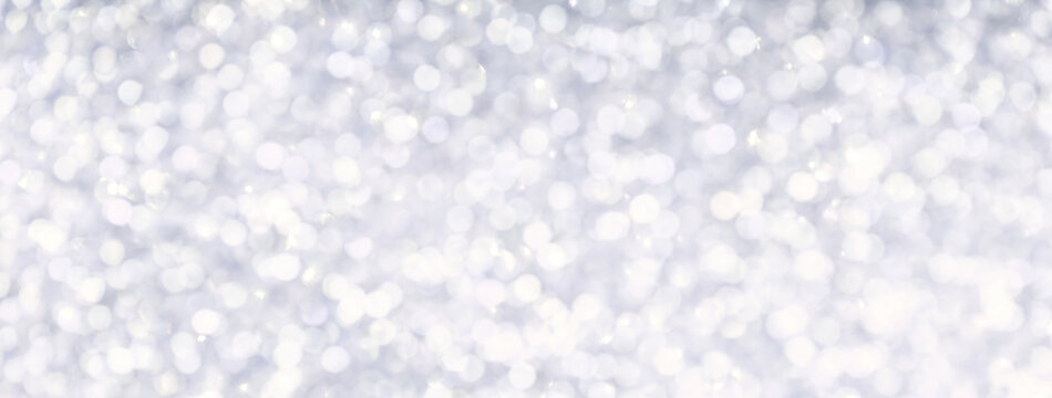 Blurred light silver sparkling background from small sequins, macro. Brilliant and diamond pearl white defocused backdrop