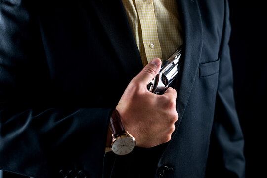 One Male Spy In A Professional Tuxedo Holds A Revolver Pistol Before The Start Of A Film Shoot.