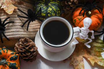 Obraz na płótnie Canvas Halloween decor with a cup of hot coffee on the window sill