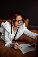 The girl prints on a typewriter. Creating a book. The writer is at work