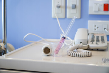 Liquid medicine in a cup with the patient's oral syringe,water pills for children