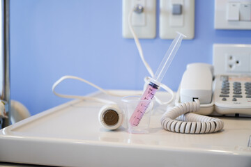 Liquid medicine in a cup with the patient's oral syringe,water pills for children