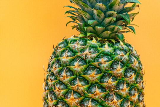 nice fresh ripe pineapple detail on orange background