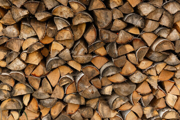 old firewood stacked in the woodpile, textured firewood background of chopped wood