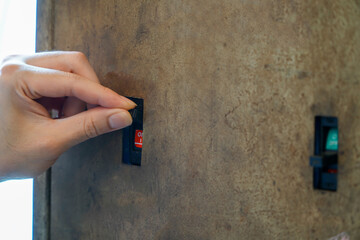 Male electrician turns off the power for an outlet at an industrial breaker box,Resetting a...