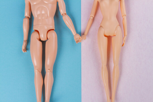 Top view naked doll couple holding hands. Blue and pink background.