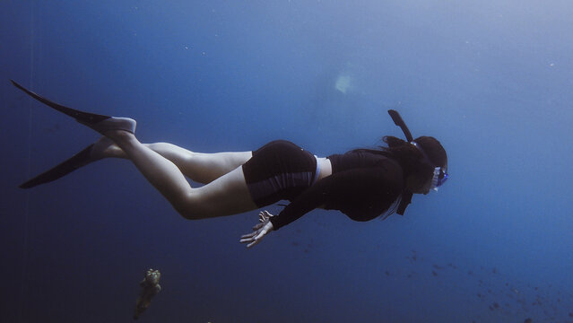 Young Woman Free Diving And Swimming In Sea Wearing Diving Equipment Like A Dive Mask And Flippers