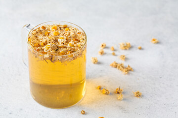 Chamomile tea with flowers in a glass cup. Healthy herbal drink, natural antiseptic.