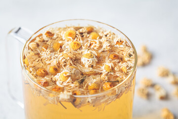 Chamomile tea with flowers in a glass cup. Healthy herbal drink, natural antiseptic.