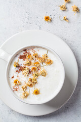 Chamomile moon milk with cinnamon in white cup. Ayurveda drink, chamomile latte tea.