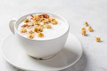 Chamomile moon milk with cinnamon in white cup. Ayurveda drink, chamomile latte tea.